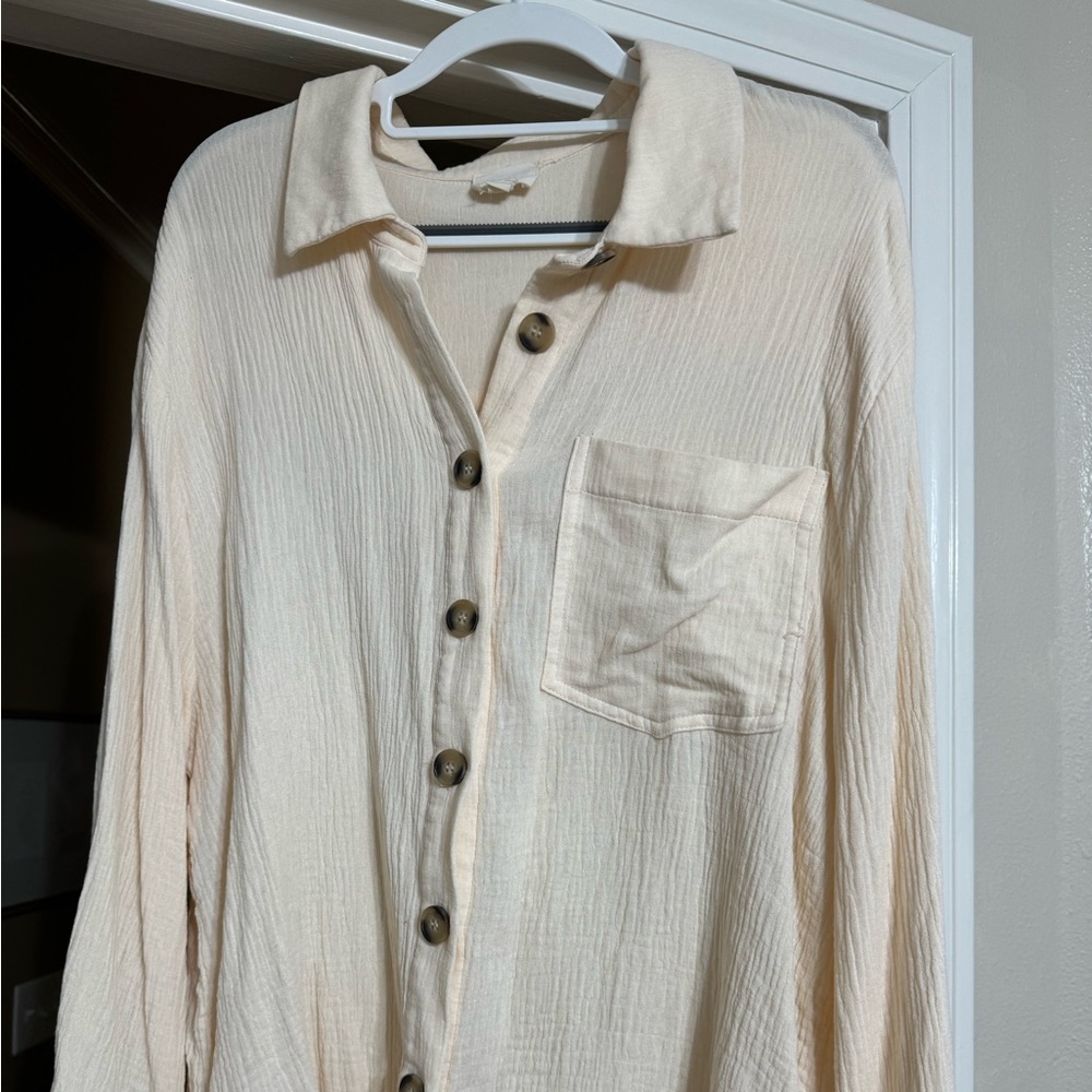 Cream colored boutique button down shirt. Can be worn open or buttoned.
